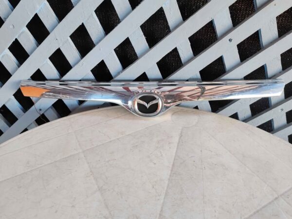 Bisel cromado de máscara Mazda 323 1998 - 2000